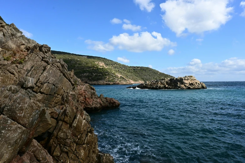 rocks in the ocean with a small island on one side