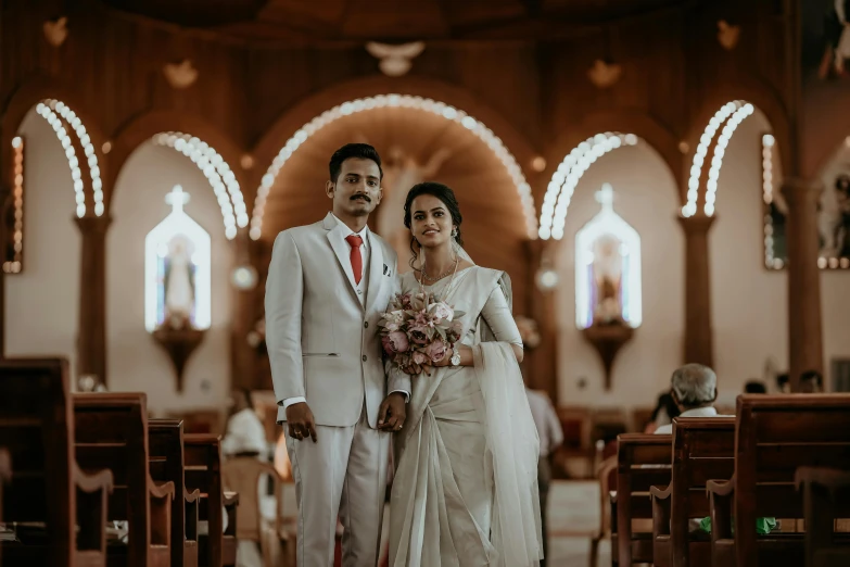 man and woman dressed in elegant white attire on a church aisle