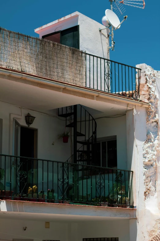 a white apartment building with a spiral stair case