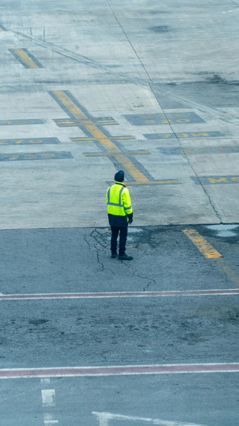 an airport worker is standing in the rain