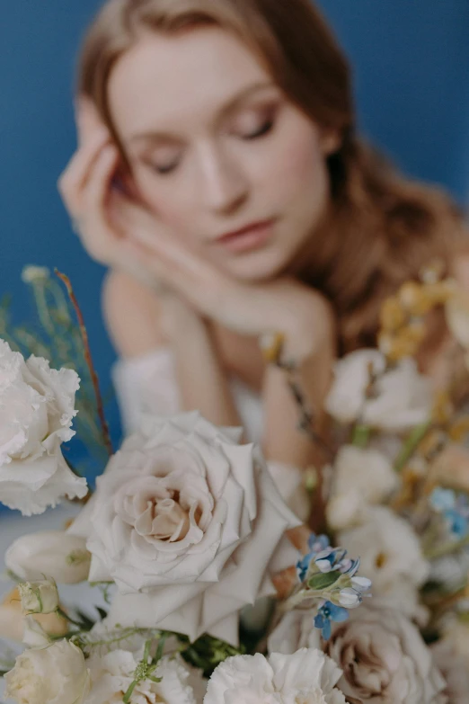 the woman has flowers in her hand near her face