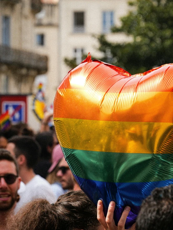 the woman has her heart shaped balloon in front of the crowd