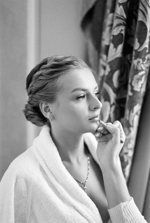 a woman in a bathrobe putting on her teeth