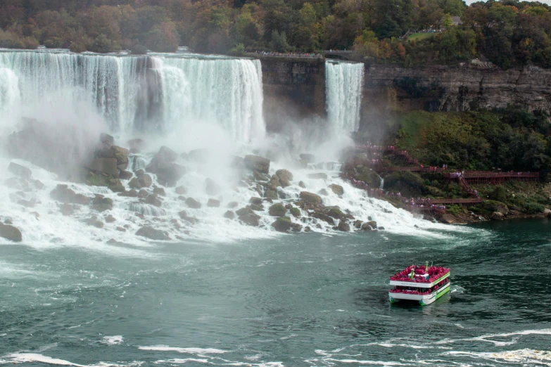 a boat is on the river near a waterfall