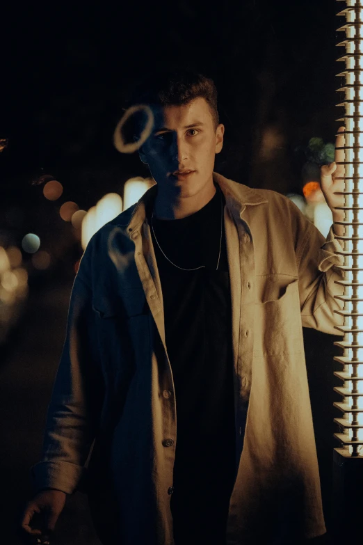 man standing outside by window with white and black circles behind him