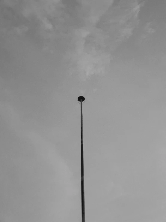 a tall metal pole sitting next to a large clock