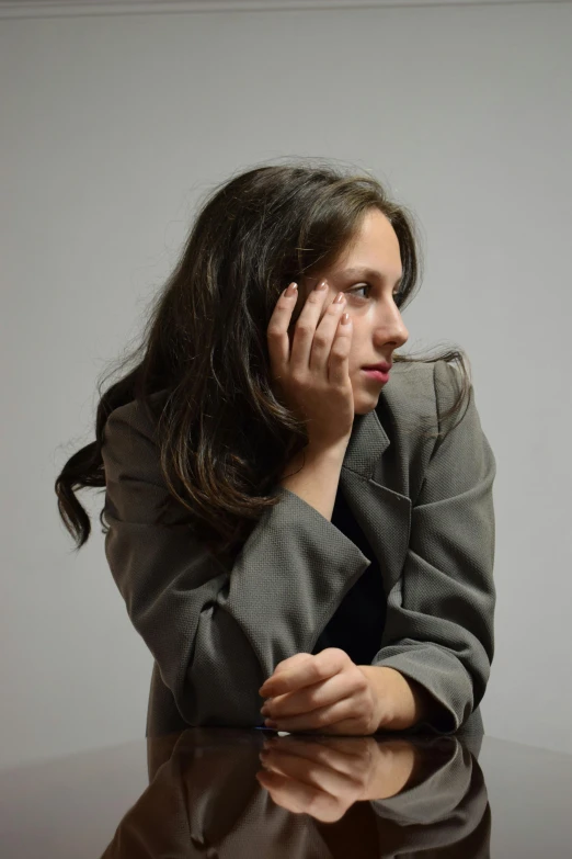 a woman wearing a suit and talking on a cell phone