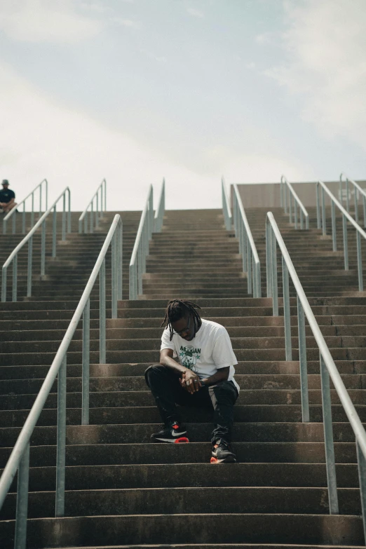 a person sitting on some stairs next to skateboards