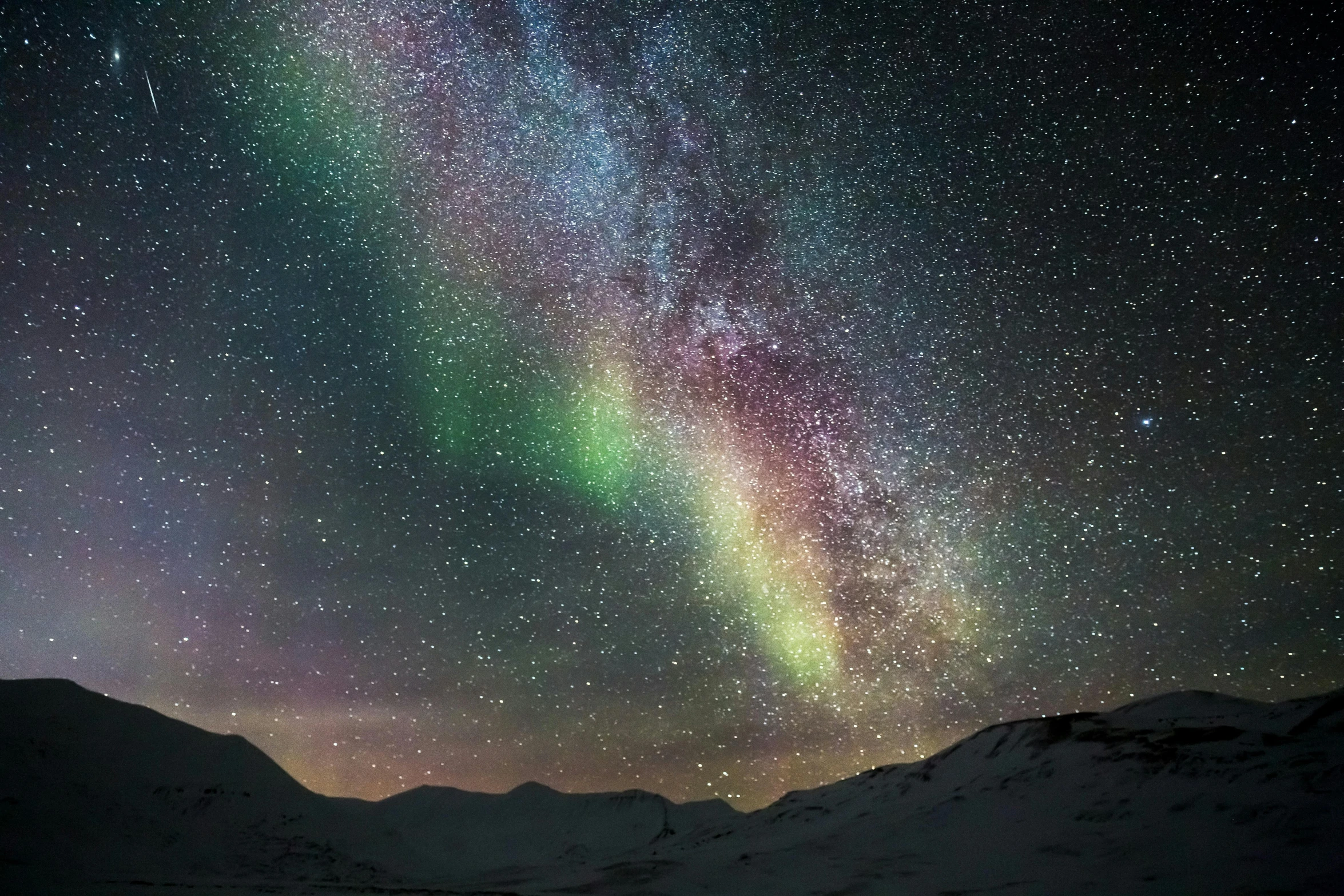 a beautiful multi colored aurora light over a snowy field