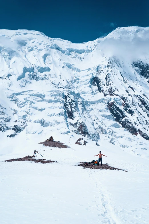 the man is standing in the snow near the mountains