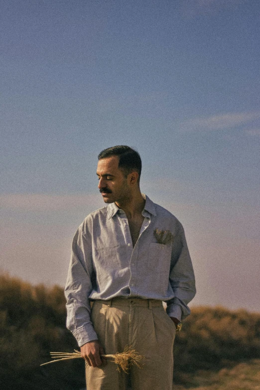 a man holding straws standing in the desert