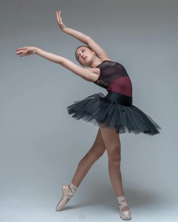 a young woman in a ballet outfit doing an acrobatic move