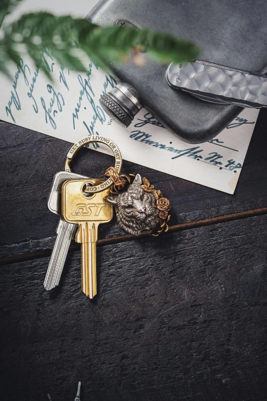 two keys on top of a table next to an envelope