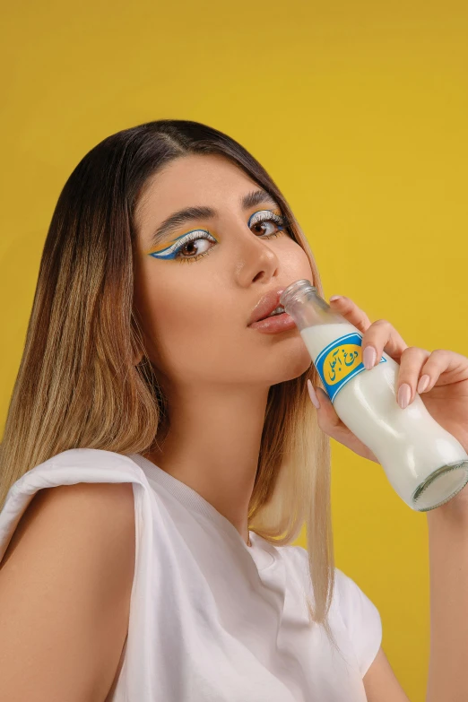 woman drinking from a bottle while wearing eyeliners