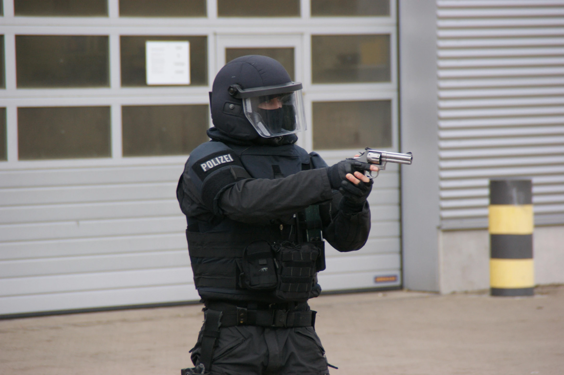 a swat police officer in full gear holding a handgun