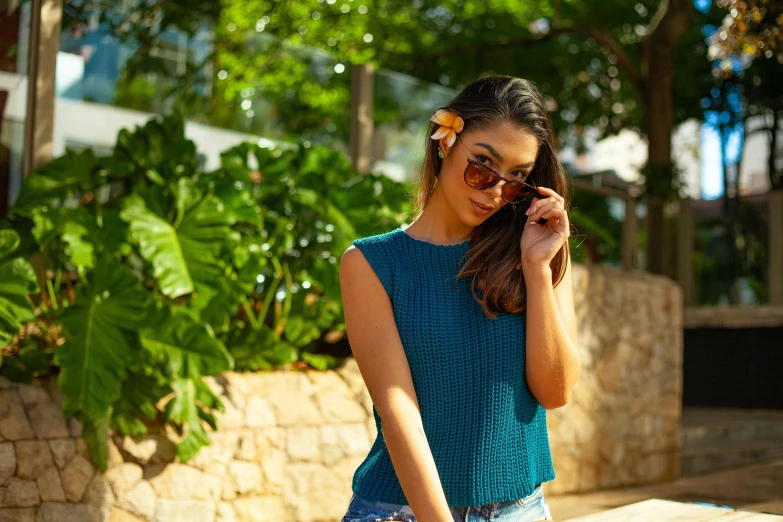 the woman in sunglasses is standing outside talking on her cell phone