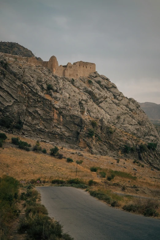 the view of a rocky hill with an asphalt road below