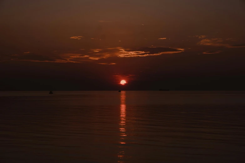 sunset in po with dark sky and a boat on water