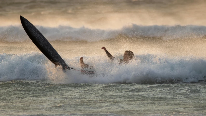 people surfing waves in the ocean near an umbrella