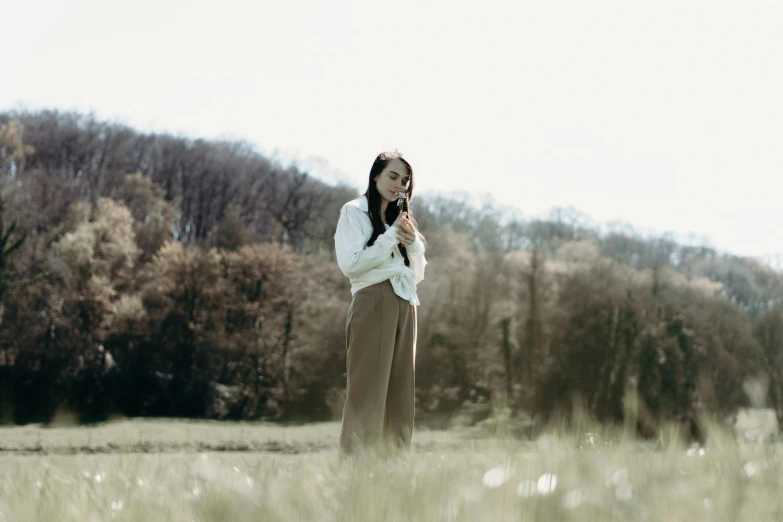 the woman is standing in the middle of a field