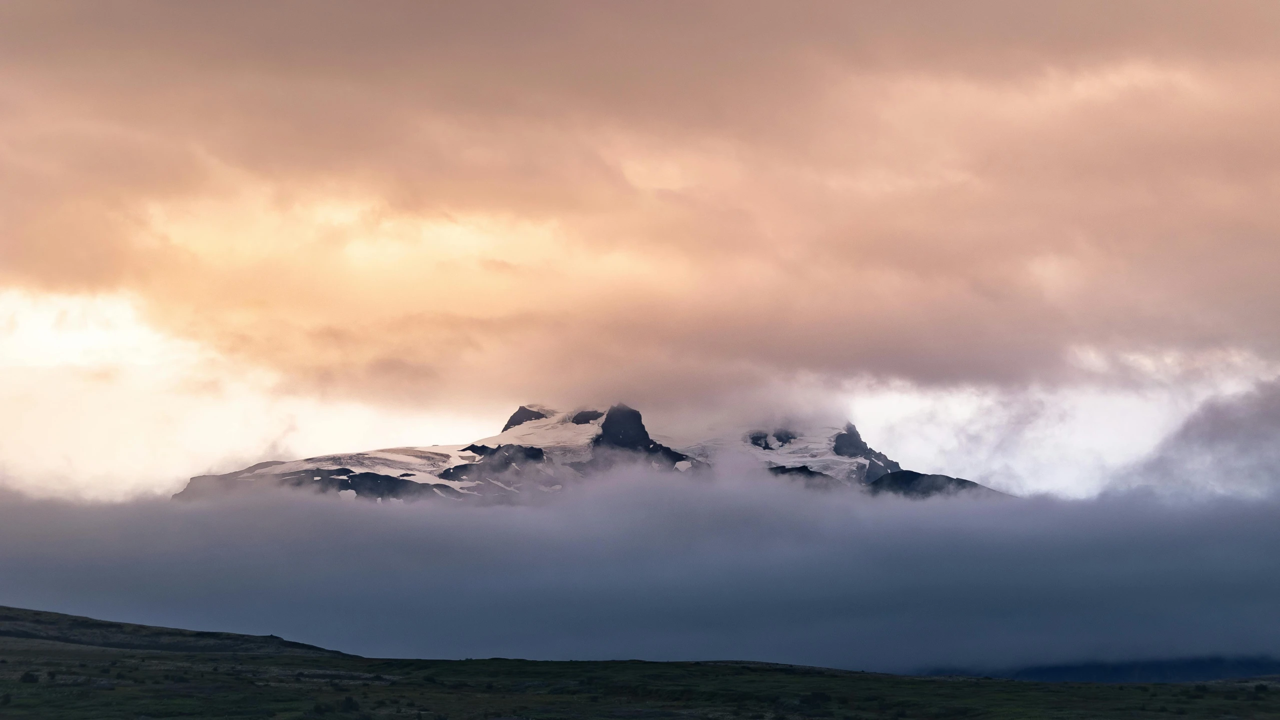 some clouds on some mountains in the sky