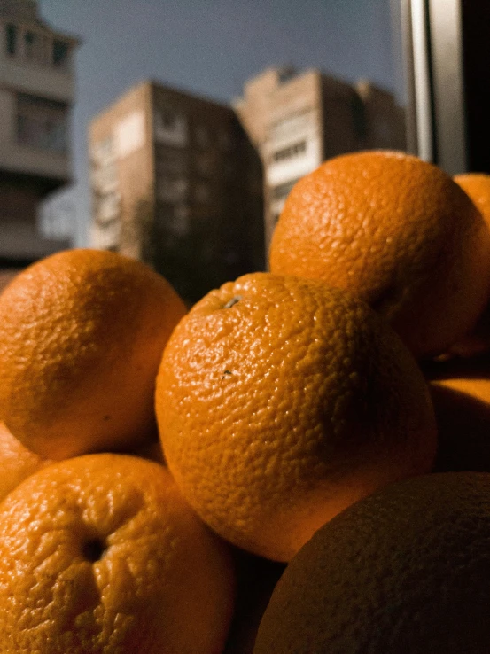 a pile of oranges in front of an office building