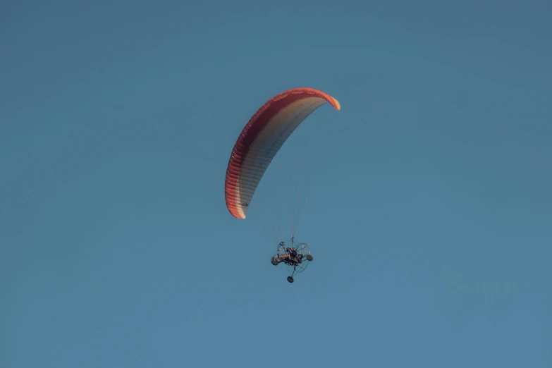 person flying on top of the glider in the sky