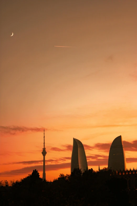 a view of two boats with sails against a sunset