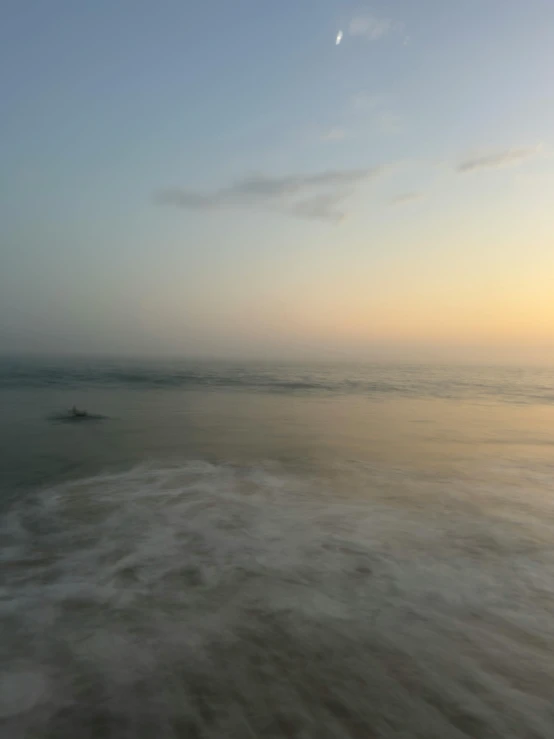 a picture of a beach at sunset with waves coming in