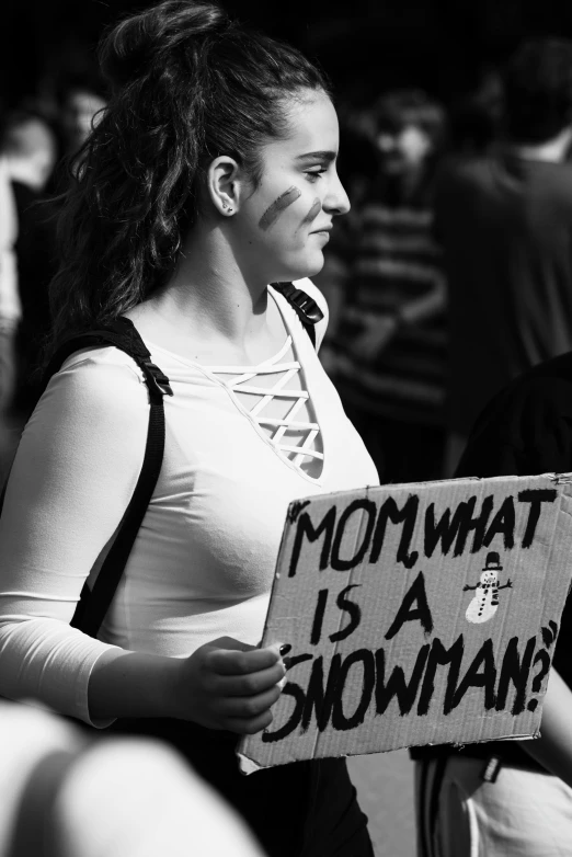 a woman is standing with a sign and holding soing