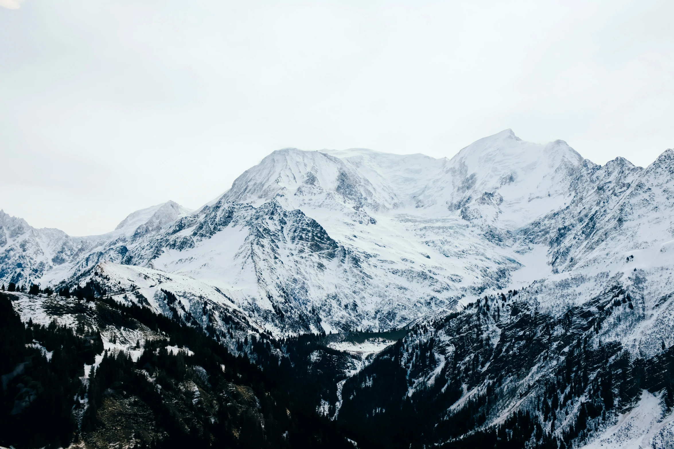 a mountain range covered in snow on a sunny day