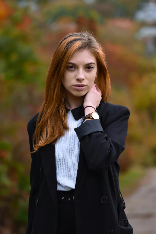 a girl wearing a black coat is looking at the camera
