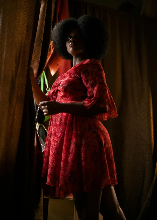 a woman in a red dress posing with her hand on her hip