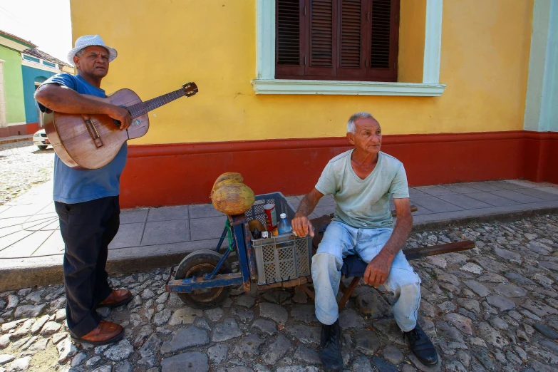 a man sitting on a bike playing a guitar