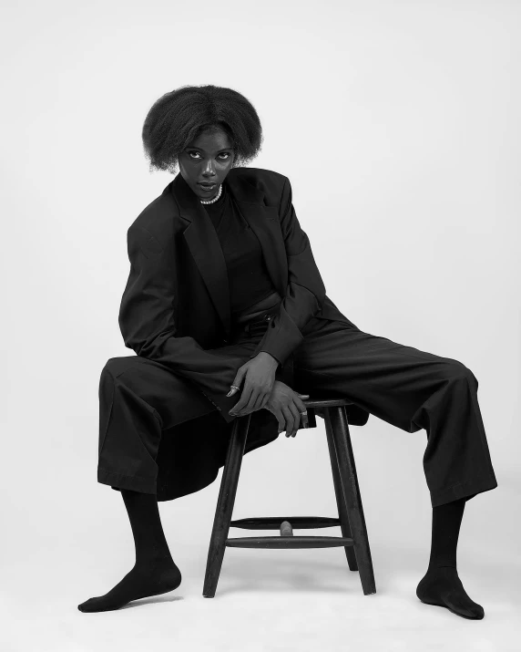 a woman sitting on top of a wooden stool