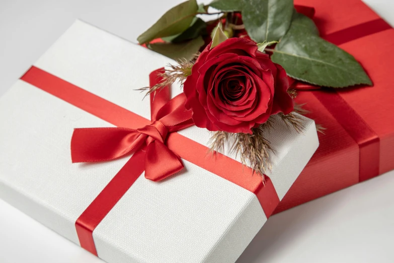 a rose in a white box with a red bow