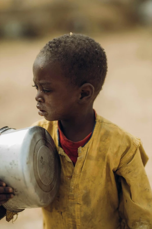 the young child is holding onto the drum