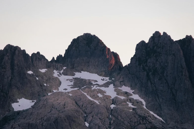 a snow - covered mountain with a couple of large rocks