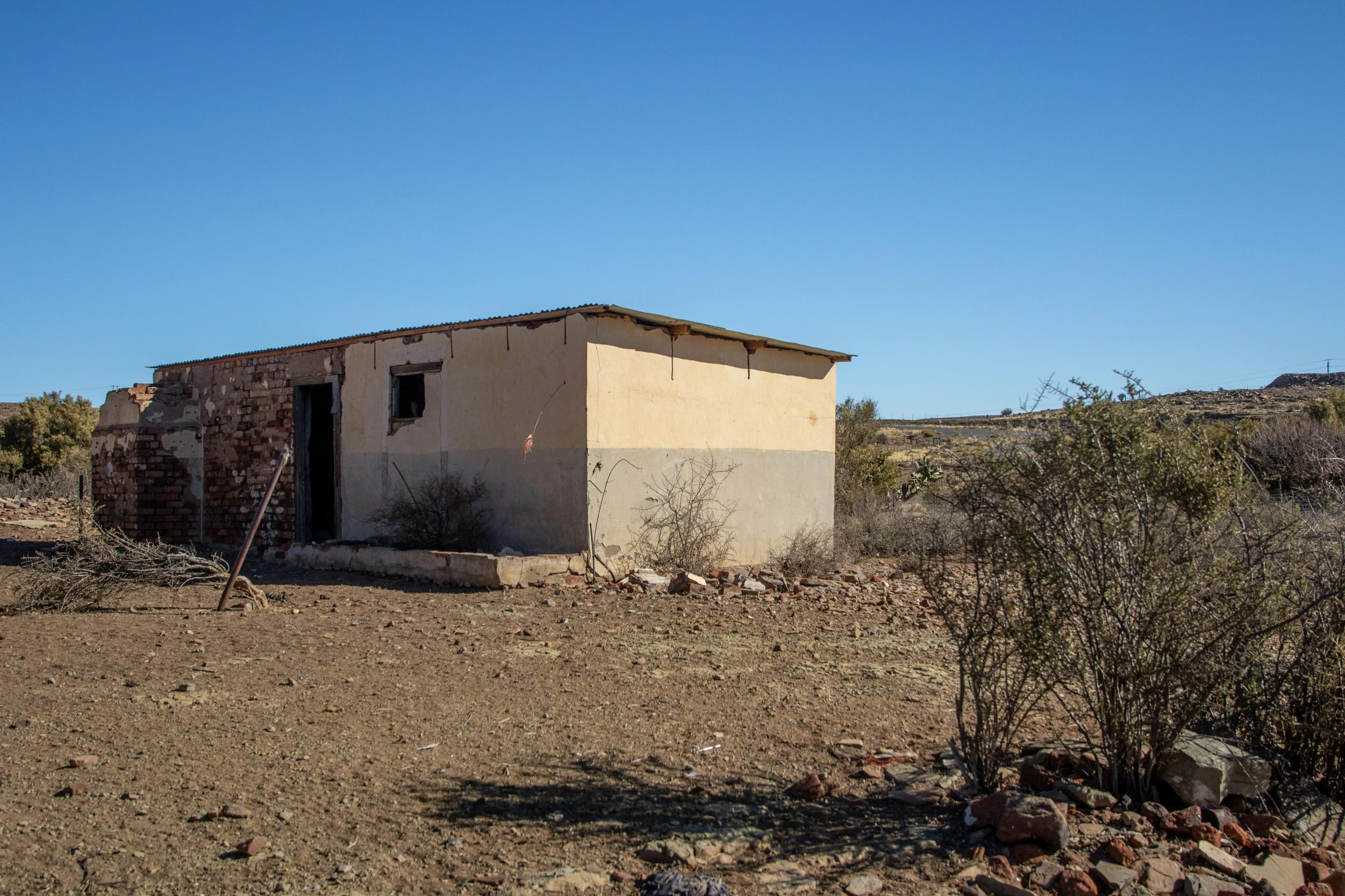 a building that is sitting on the side of a dirt road