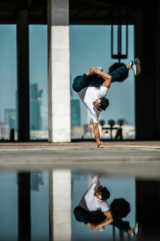 a man performs yoga outside in front of the city's sky