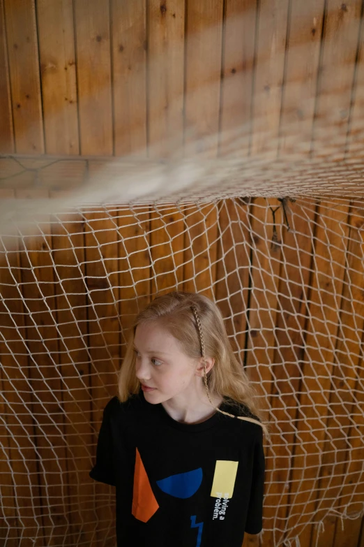 a little girl standing in front of a net