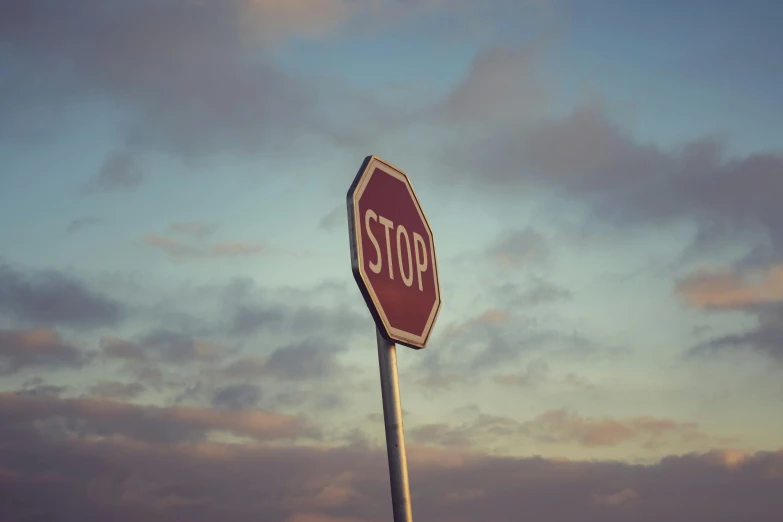 a stop sign in front of cloudy sky