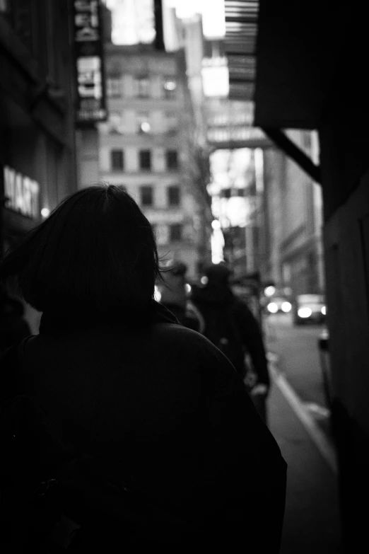 a person in a dark jacket walks down a street