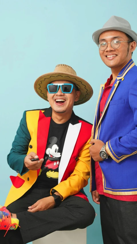 the two men are dressed in hats and holding a cell phone