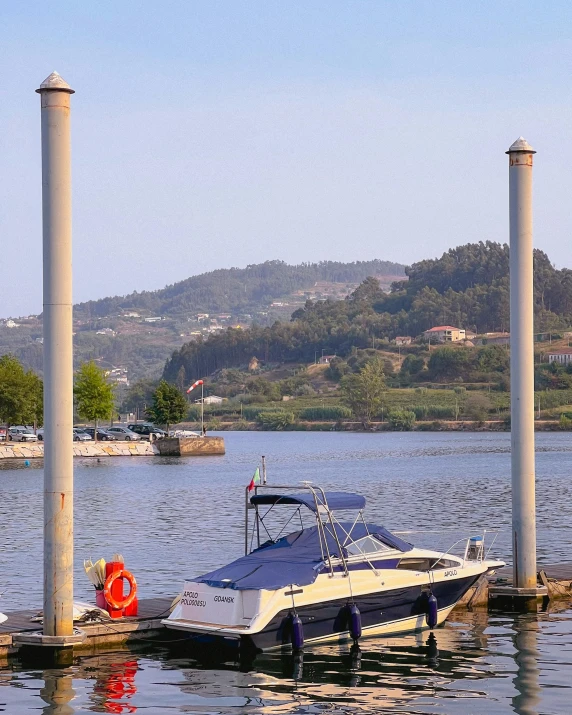 a boat is docked on a dock near some poles