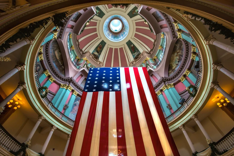 an american flag hanging from the ceiling of a large church