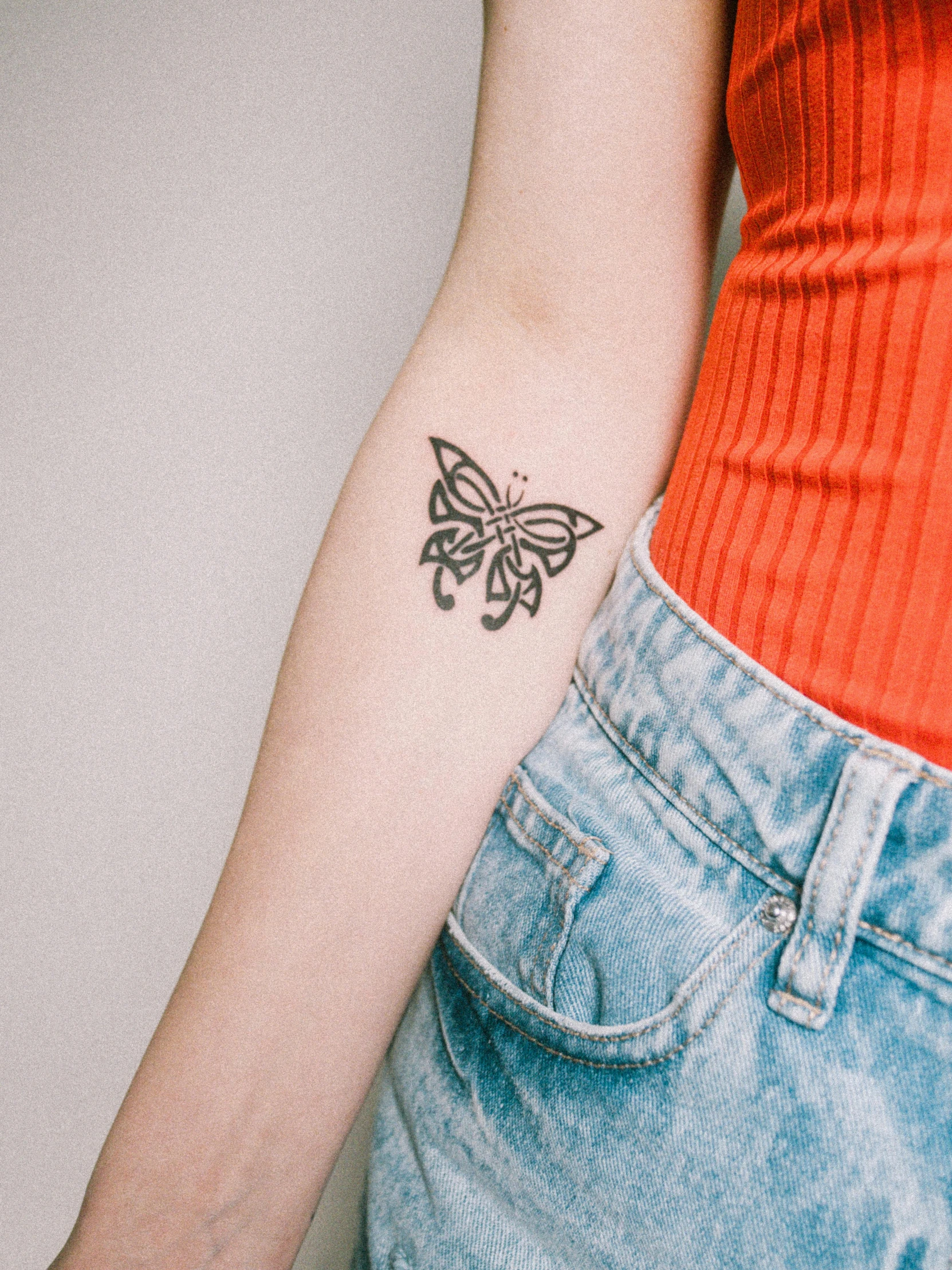 a female with a erfly tattoo on her arm