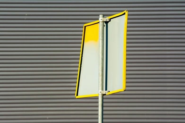 a street sign stands in front of a gray garage wall