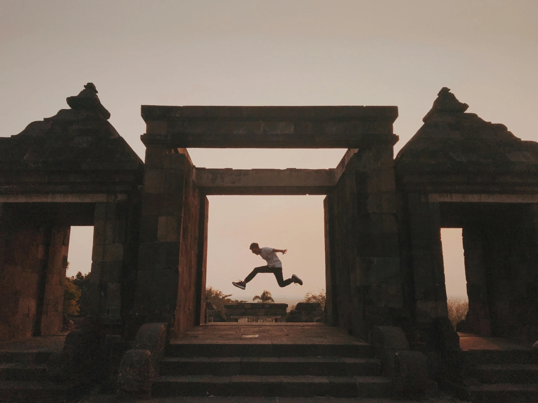 man running through doorway at sunset in open area