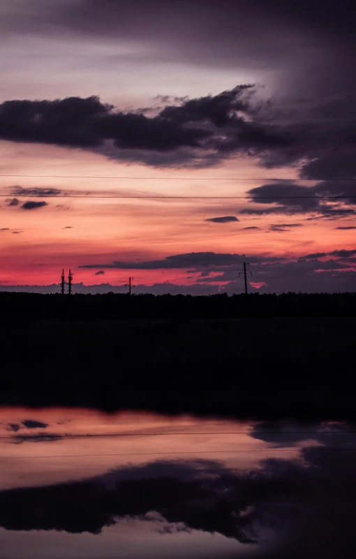 the sky over the water is lit by the setting sun